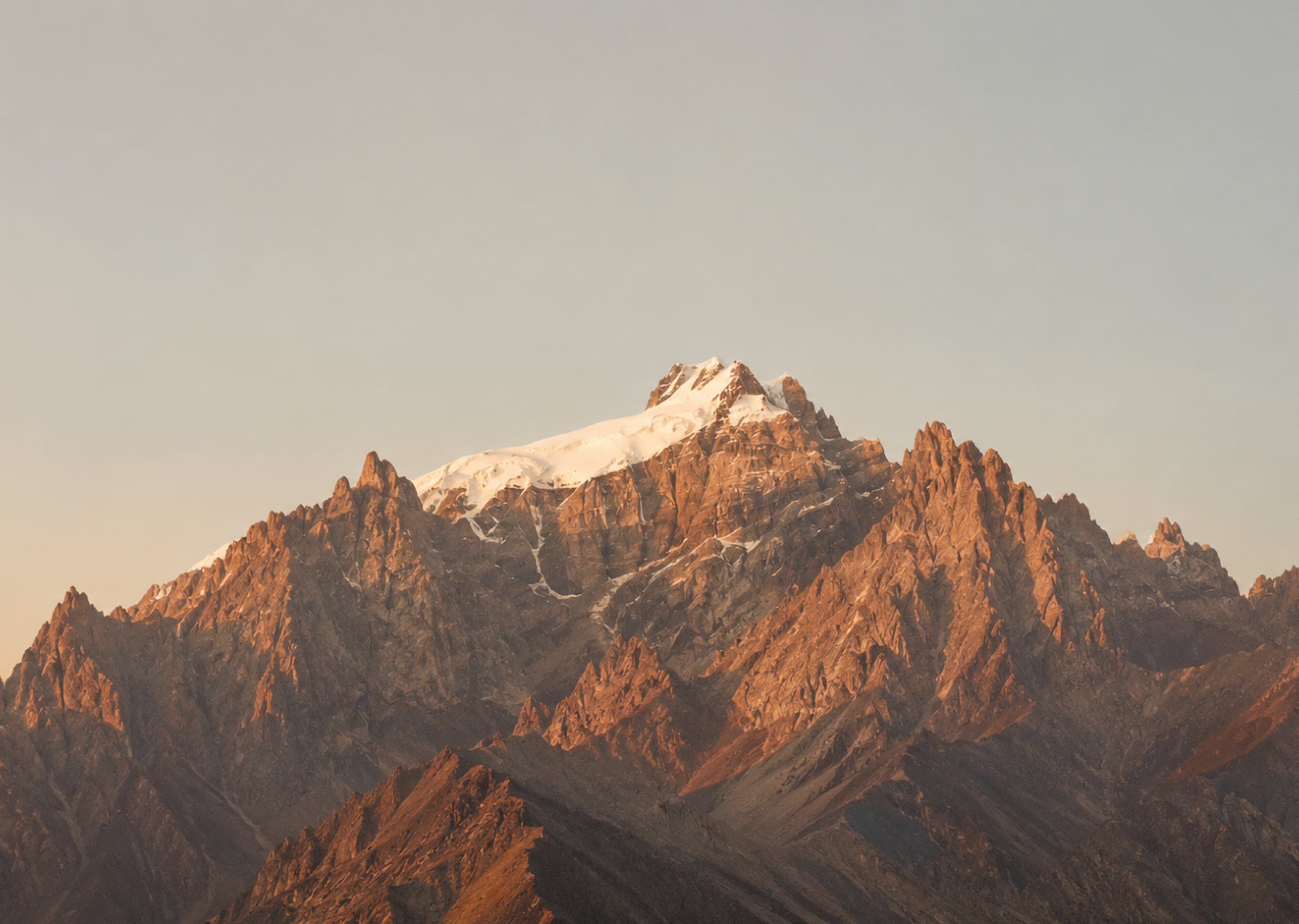 Distant rocky peaks beneath layered clouds in a watercolor style